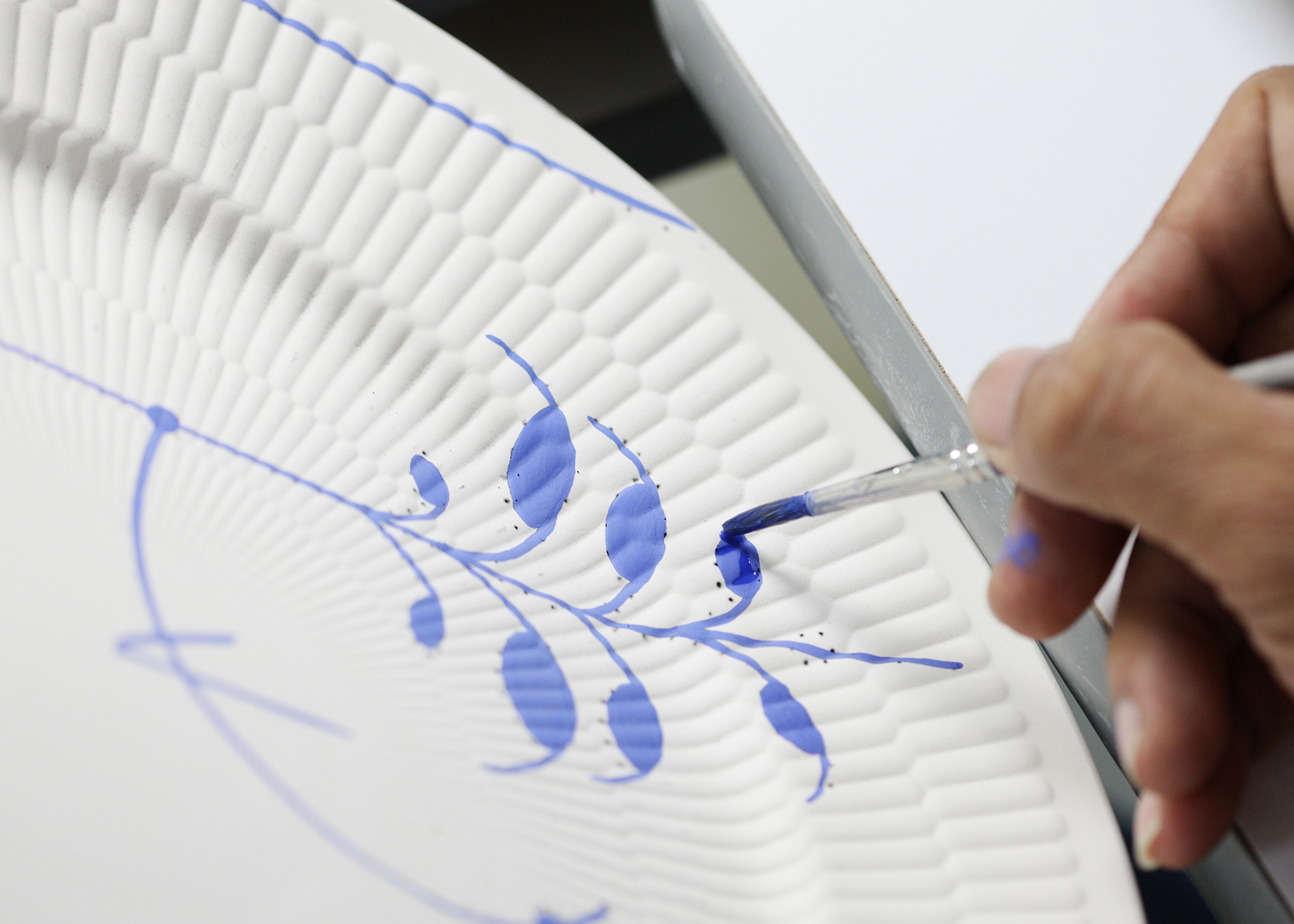 A Blue Painter is painting a Blue Mega Plate by hand